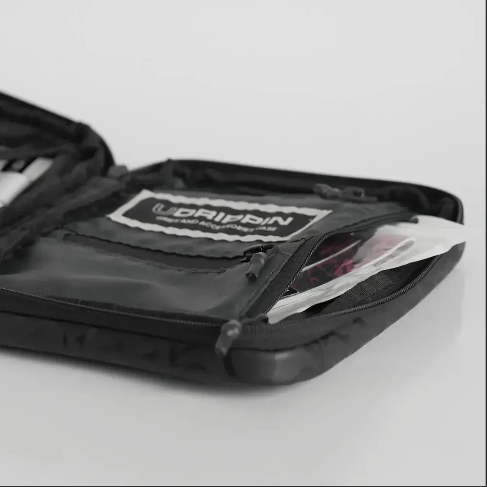 UDRIPPIN Grip Case opened, showcasing interior organization pockets and zipper detail.