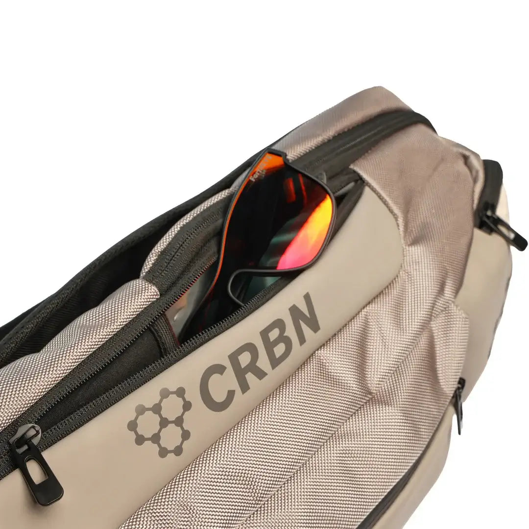 Close-up of the CRBN Pro Team Sling Bag featuring stylish sunglasses in the pocket, highlighting its sleek design.