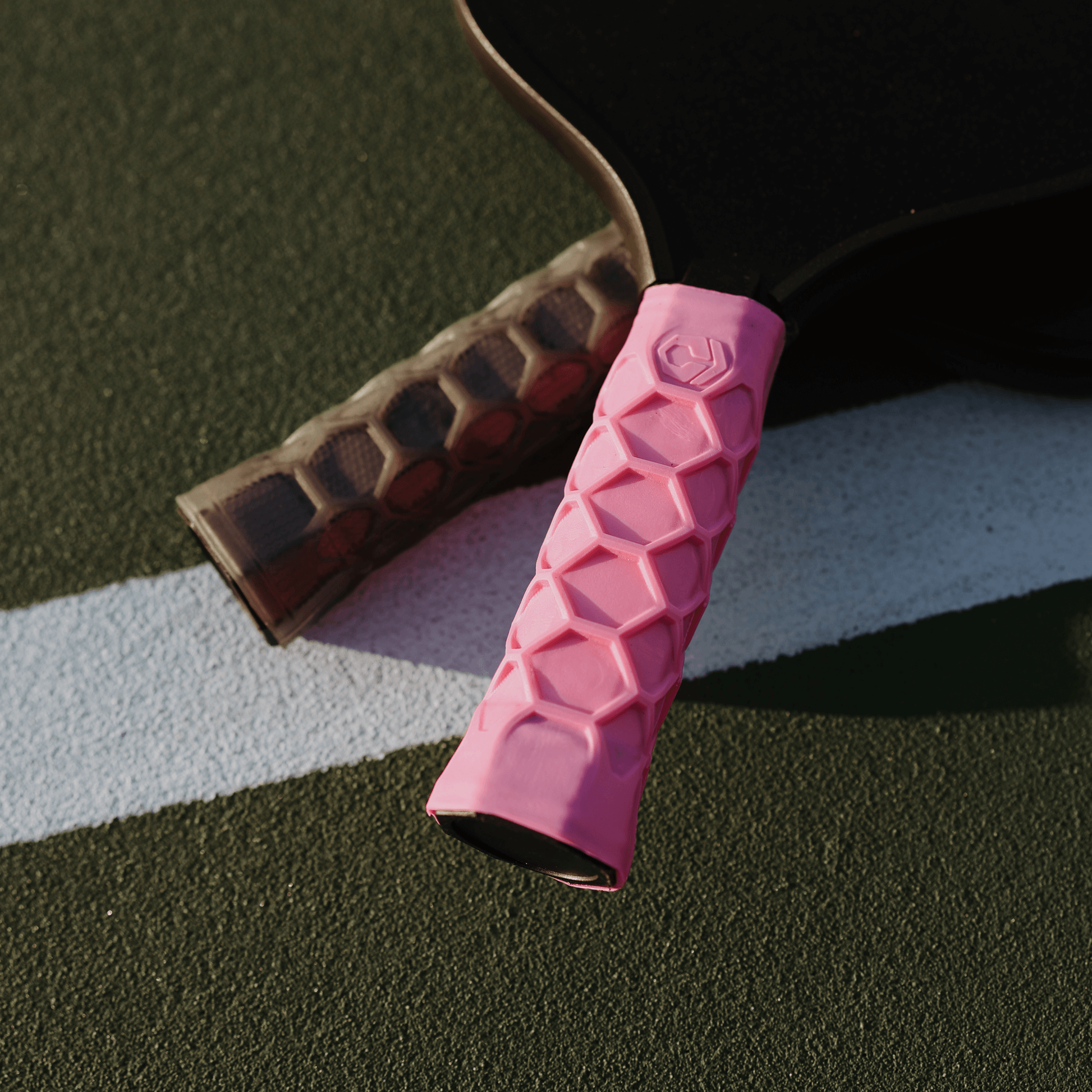 Pink Hesacore XS Pickleball Grip with honeycomb design on a paddle absorbing sweat and vibrations for enhanced comfort and efficiency.