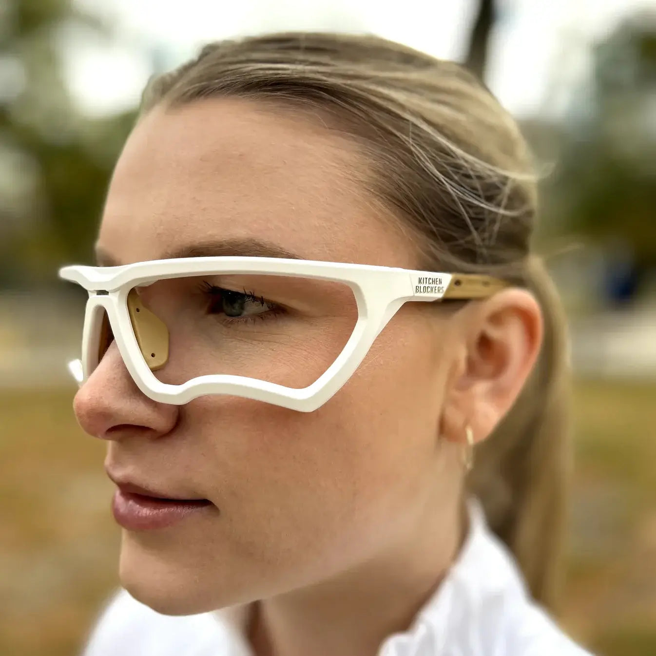 Profile view of a woman wearing Kitchen Blockers™ eye protection glasses designed for sports safety.