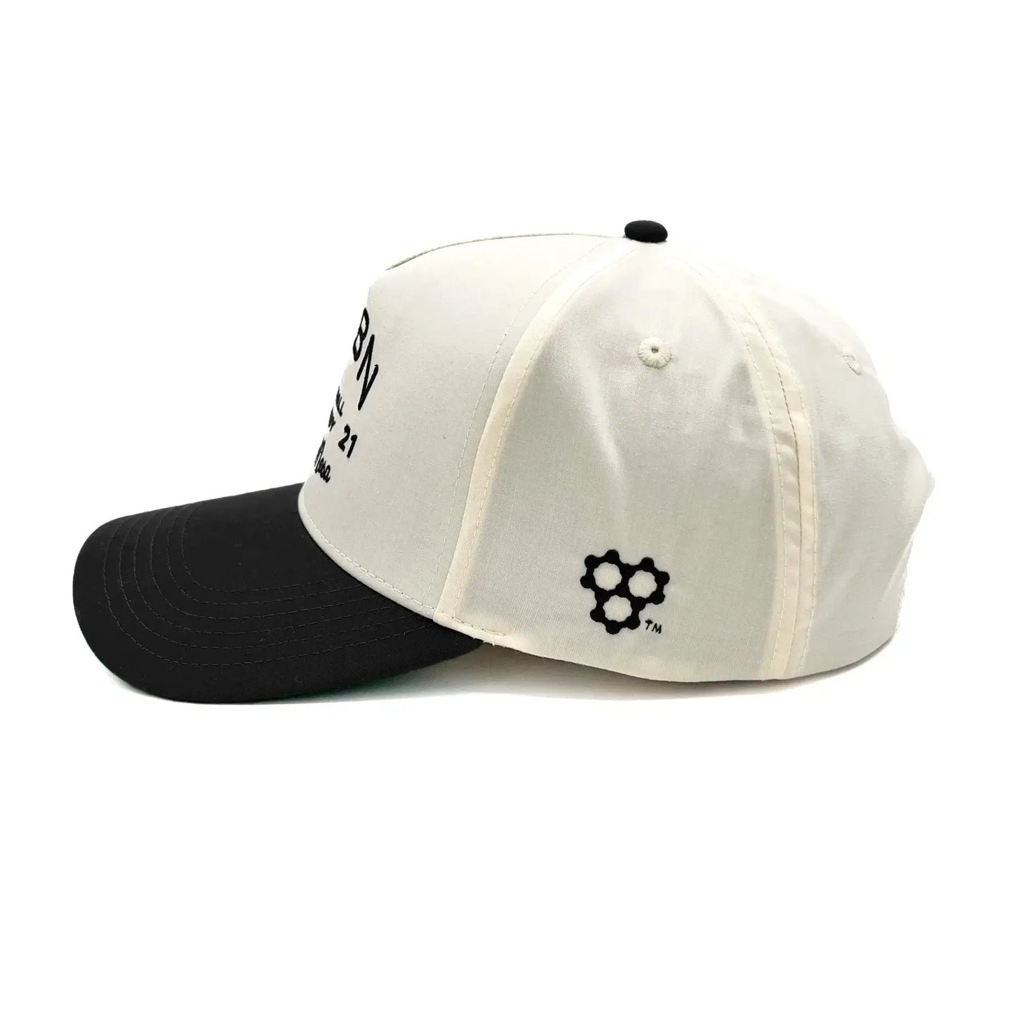CRBN Heritage Snapback hat with black brim and cream body, featuring brand logo and classic design.