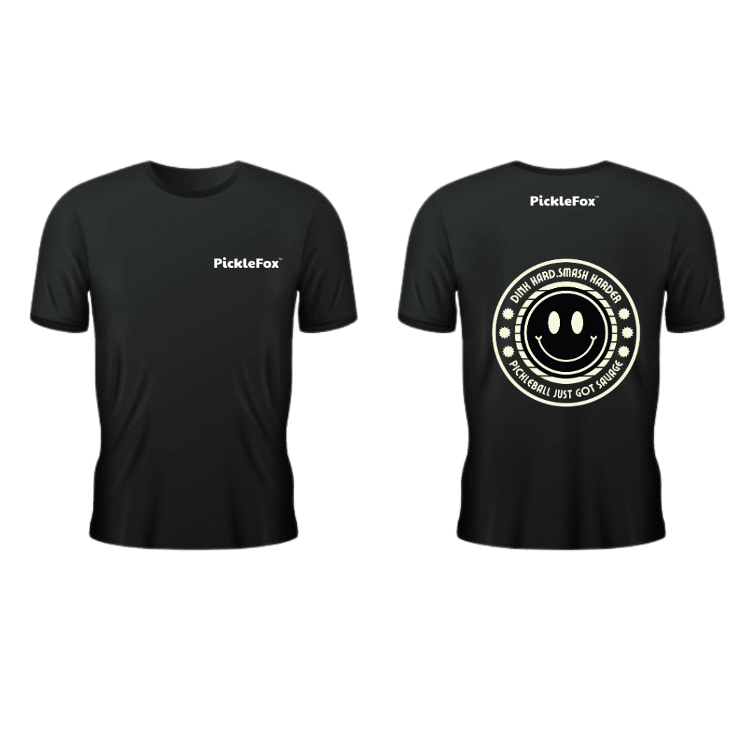 Picklefox Dink Hard, Smash Harder Performance Tee in black with smiley graphic and moisture-wicking technology.