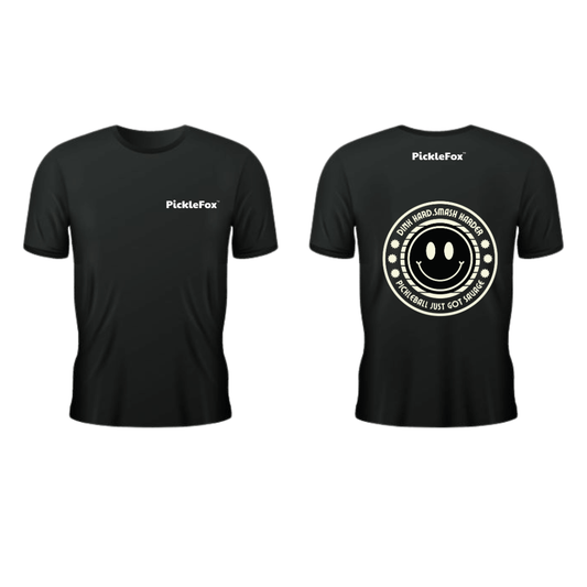 Picklefox Dink Hard, Smash Harder Performance Tee in black with smiley graphic and moisture-wicking technology.