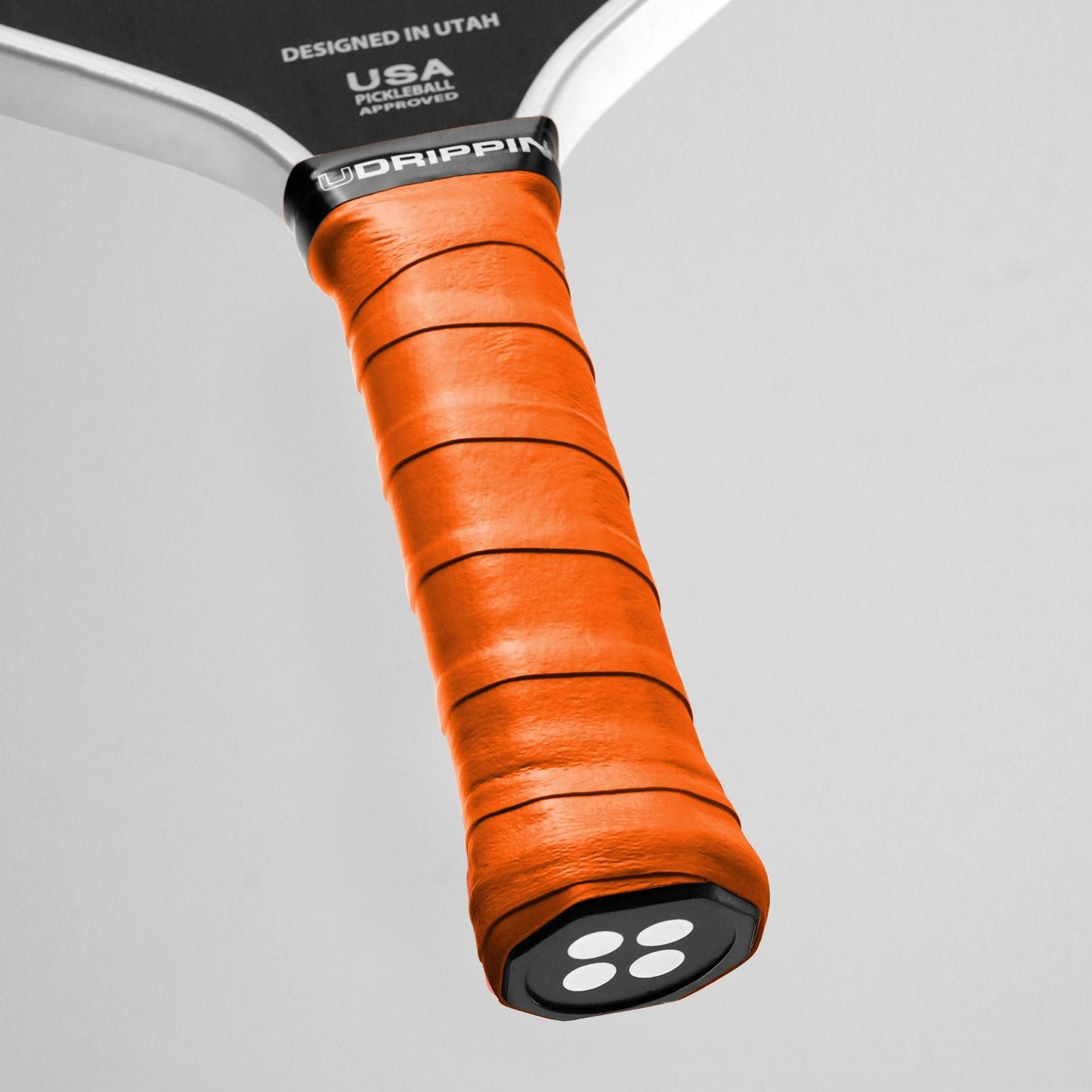 UDRIPPIN Comfort Tour Grip on pickleball paddle showing orange high-quality sweat absorbent handle with .60mm thickness.