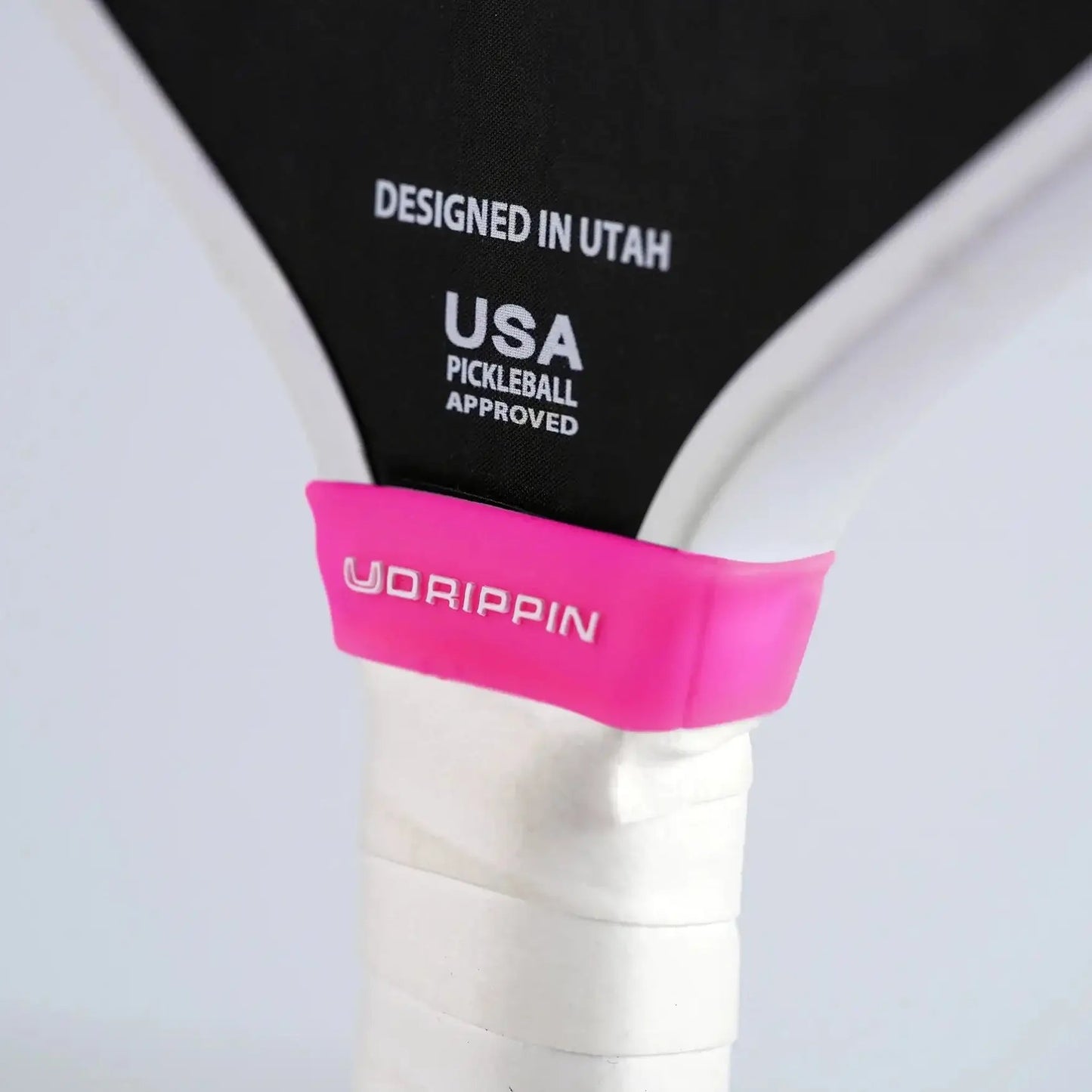UDRIPPIN Paddle Silicone Ring in pink on a pickleball paddle, enhancing grip, designed in Utah, USA approved.