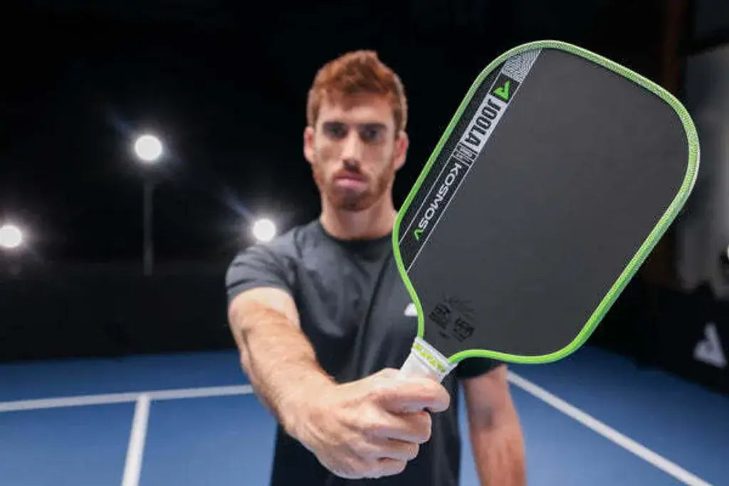Joola Kosmos Pro V Surge Green (Global) paddle held by a player on the court, showcasing its sleek design.