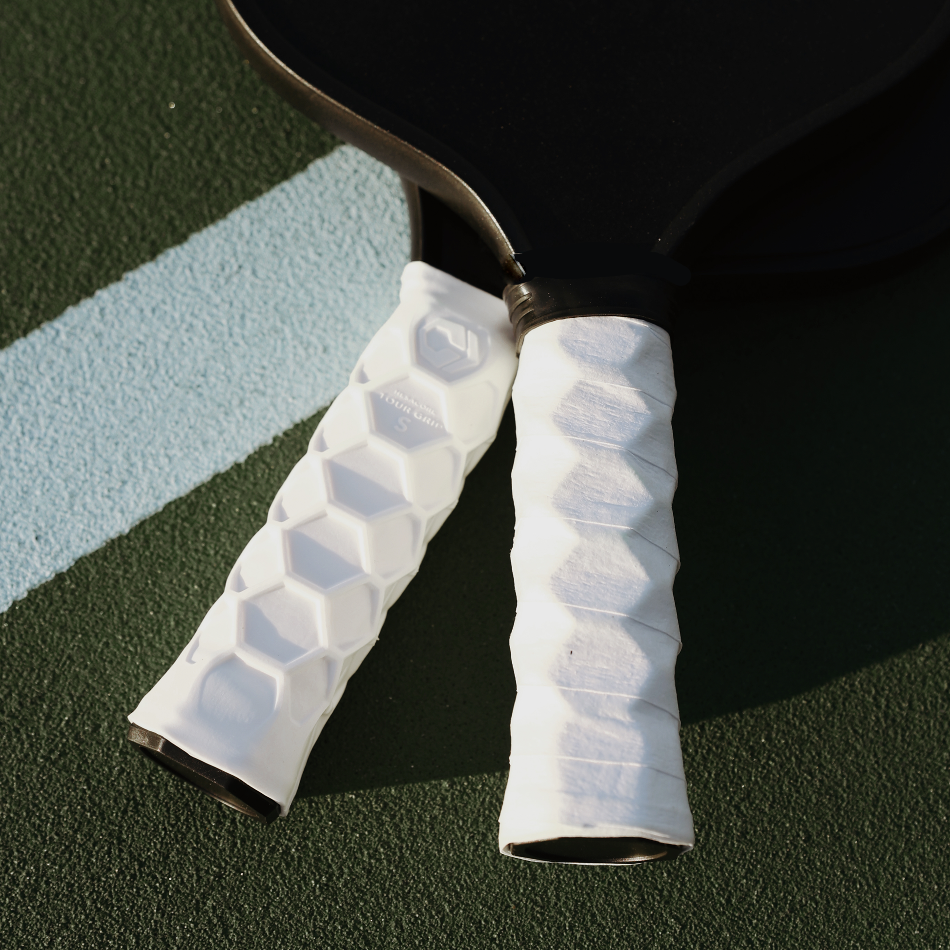 Close-up of pickleball paddles with Hesacore S grips featuring white honeycomb design for improved comfort, efficiency, and sweat absorption.