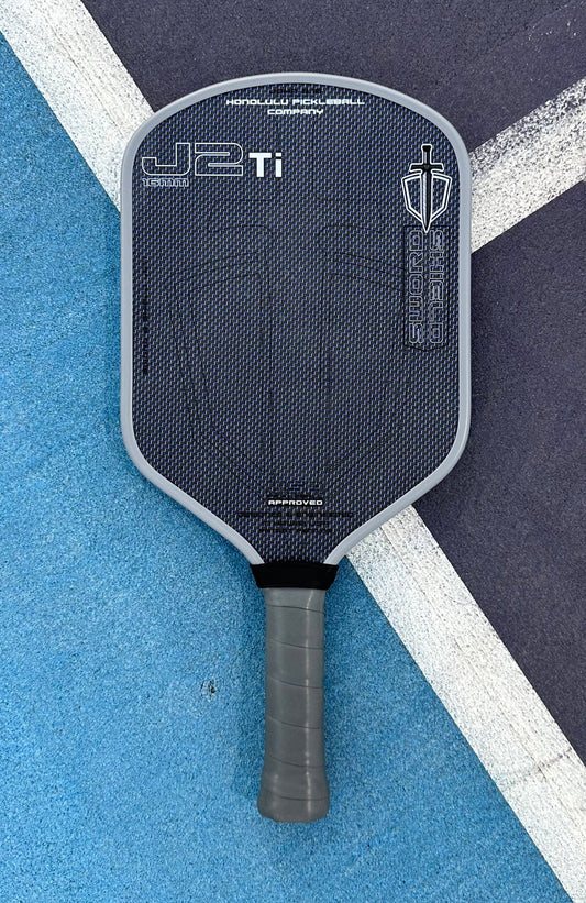 Honolulu Sword & Shield J2Ti paddle with Aero Hybrid Plus shape, blue design, offering power, spin, and control. Pre-order available.