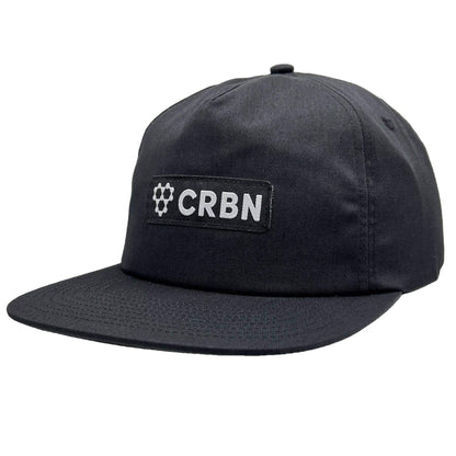 CRBN Essential Snapback Hat in black, featuring a woven patch and adjustable snapback closure.