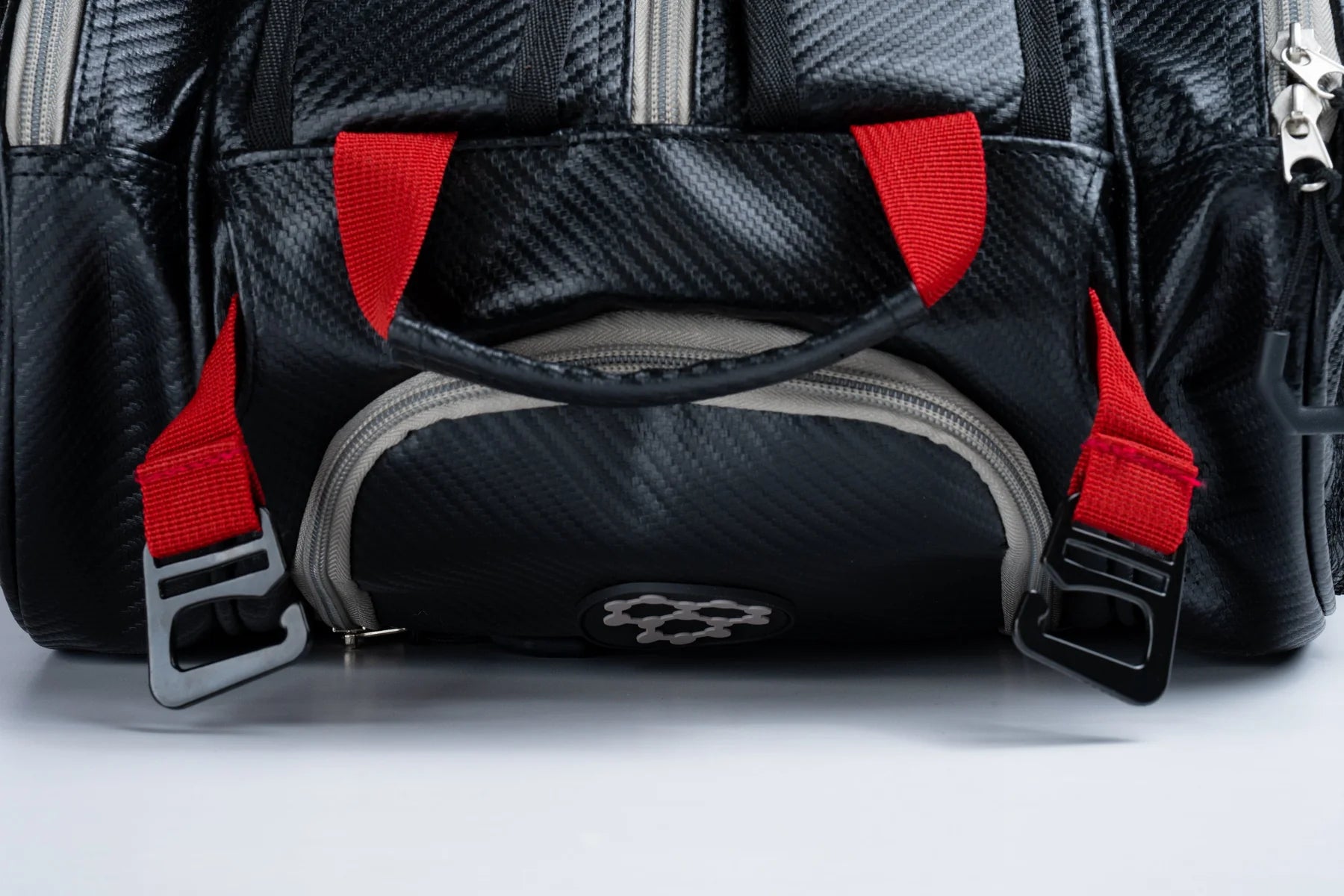 CRBN Pro Team Tour Bag 2.0 close-up showing red straps and textured black material for versatile use and durability.