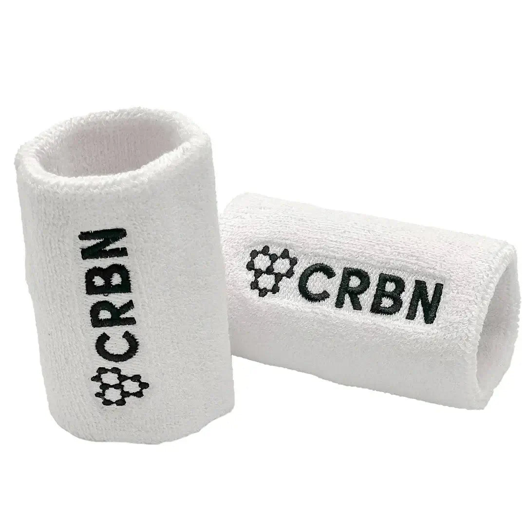 CRBN wristband set featuring two white terry loop wristbands with embroidered CRBN logo, made from cotton and nylon.