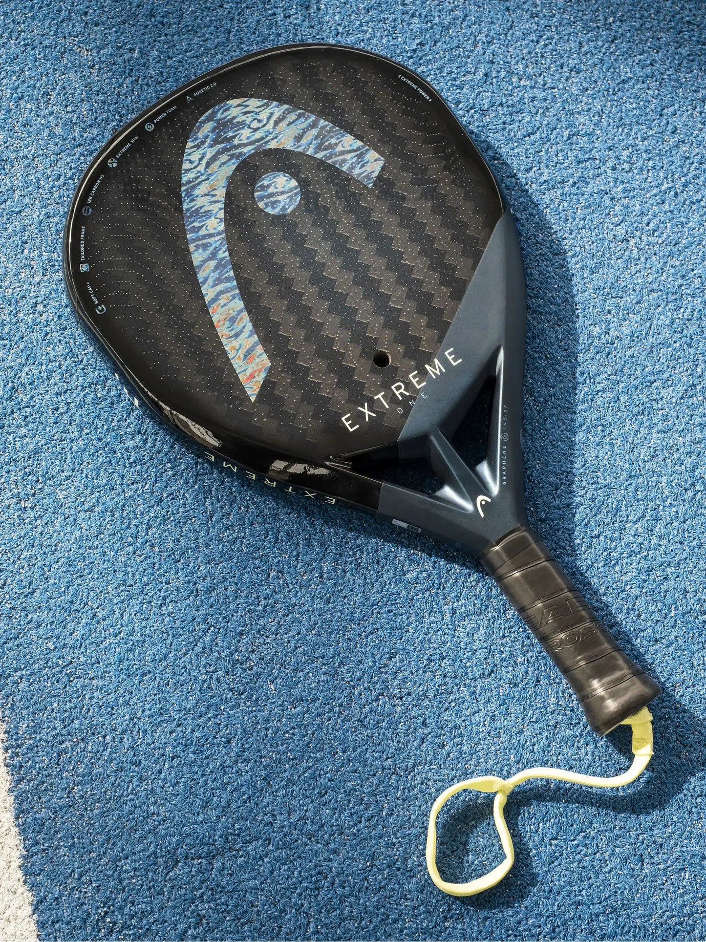 HEAD Extreme One Padel Racquet on blue court surface, showcasing its lightweight and innovative design.