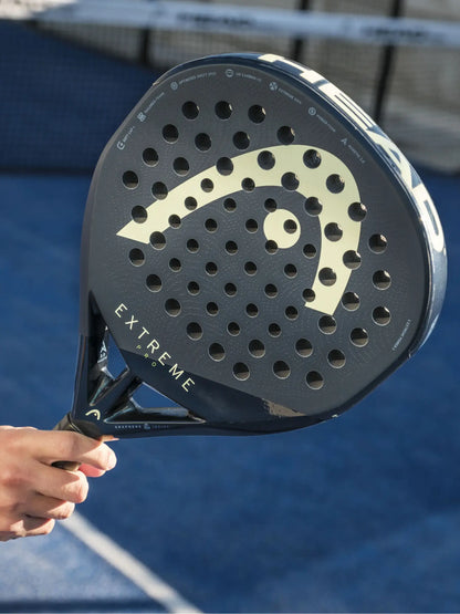 HEAD Extreme Pro Padel Racquet held on a court, showcasing its unique design and perforations for enhanced performance.