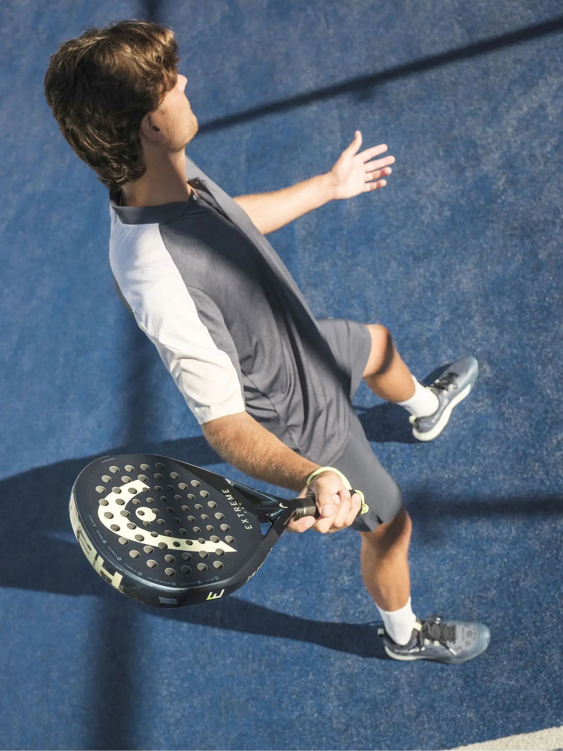 HEAD Extreme Pro Padel Racquet held by a player on a blue padel court, showcasing performance and technique.