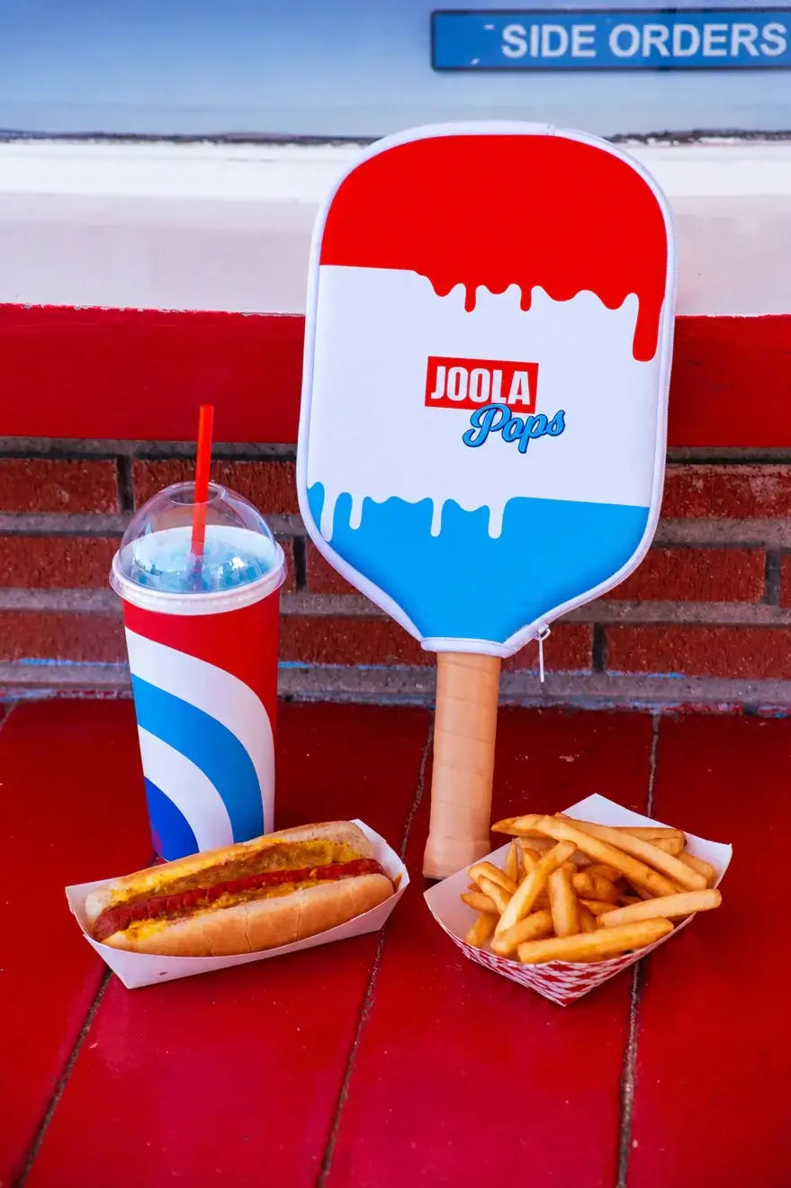 Joola Perseus Pro V Rally Rocket (Limited Edition) alongside a hot dog, fries, and a slushy drink on a red table.
