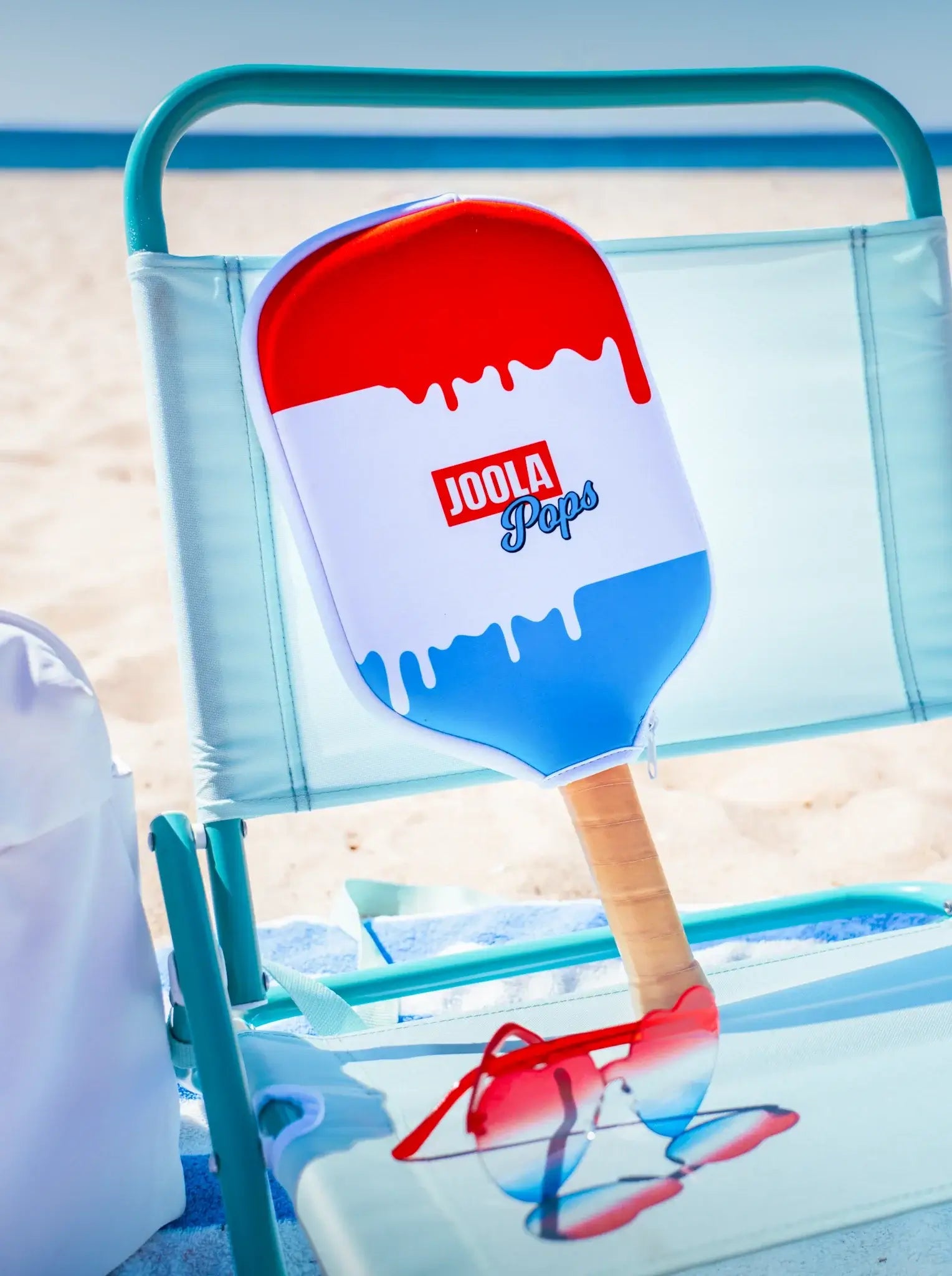 Joola Perseus Pro V Rally Rocket (Limited Edition) paddle on a beach chair with sunglasses.